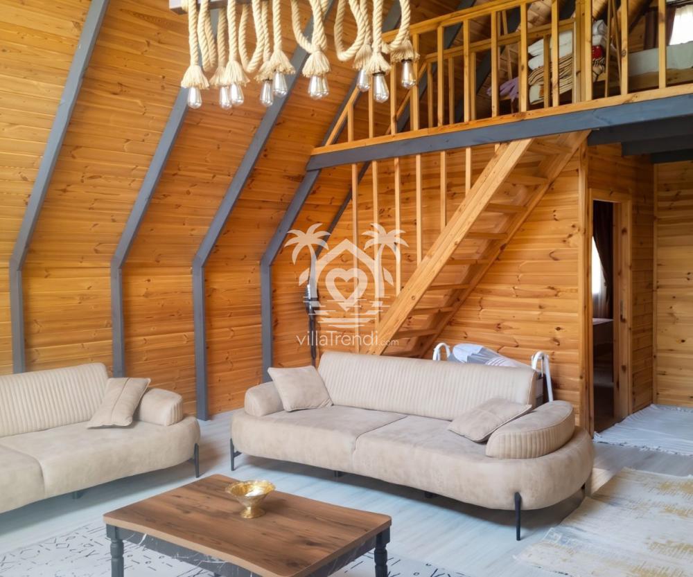 Göcek kiralık ahşap loft bungalov geniş salon oturma grubu ve loft merdiveni.