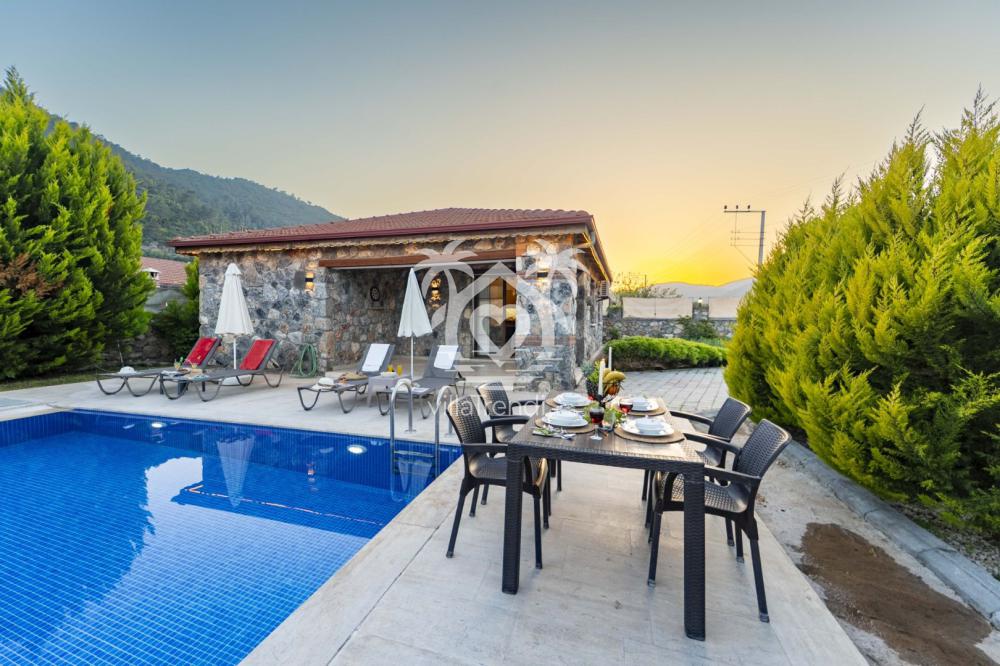 Fethiye Kayaköy kiralık villa Kaya akşam havuz başı yemek masası.
