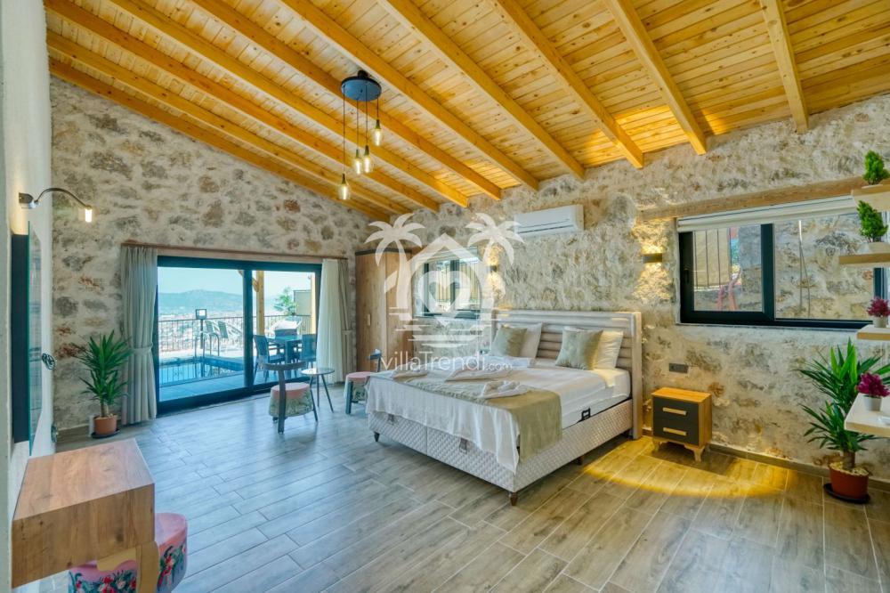 Villa Stone Uno Fethiye taş duvarlı romantik yatak odası.