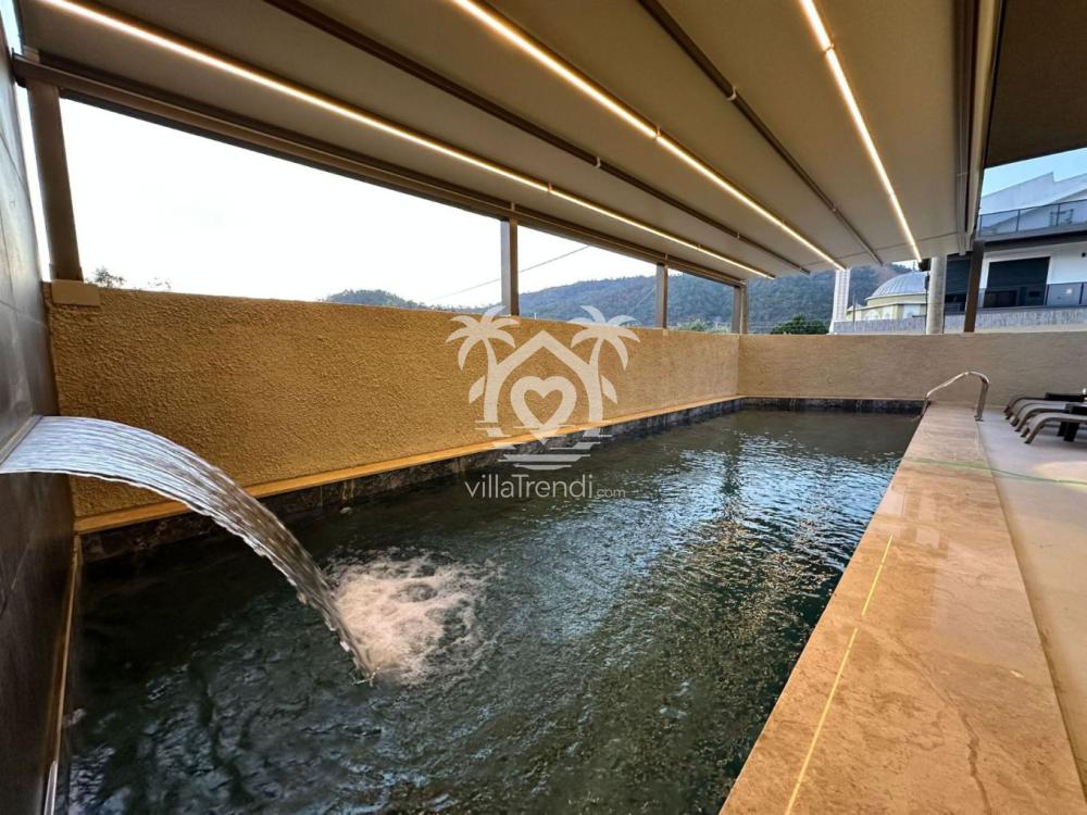 Villa Berfin Karagedik havuz içi şelale detayı ve şezlonglar.