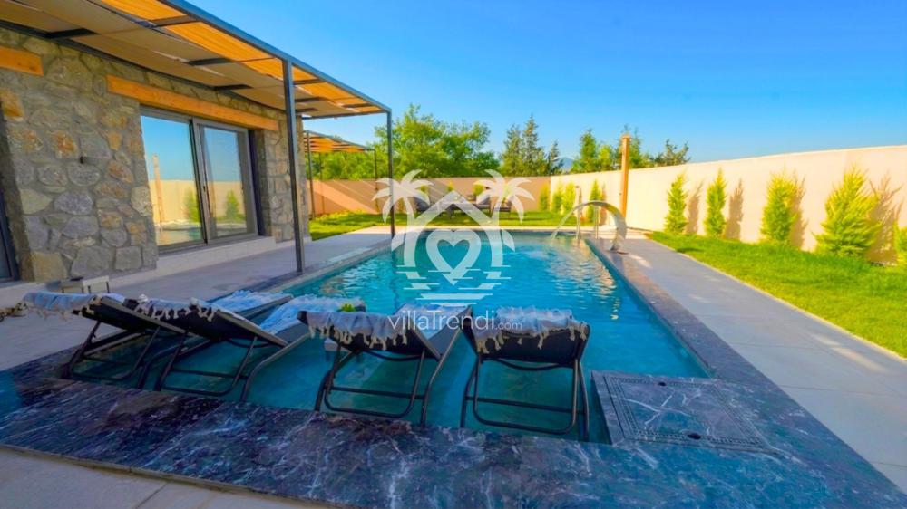 Fethiye Seydikemer kiralık taş ev korunaklı havuz terası ve şezlonglar.