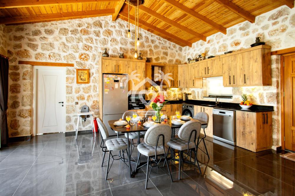 Kalkan kiralık villa ahşap tavanlı geniş açık mutfak ve yemek alanı.