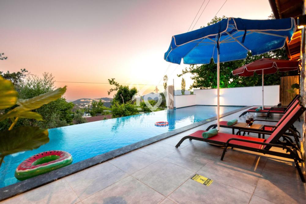 Villa Oran gece ışıklandırmalı özel yüzme havuzu ve şezlonglar.