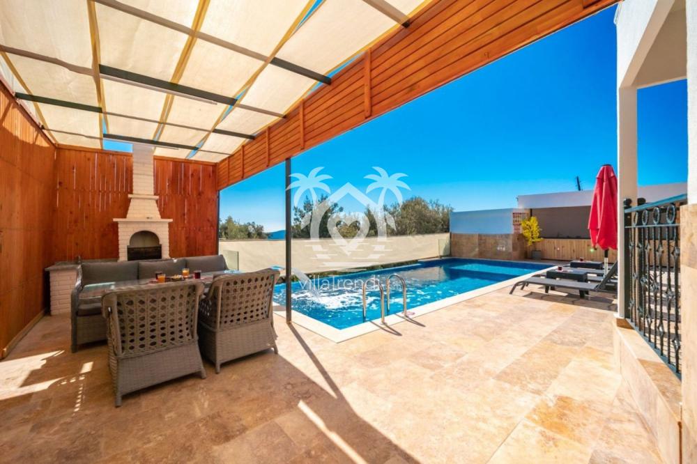 Kalkan korunaklı villa açık hava mutfağı ve taş barbekü alanı.