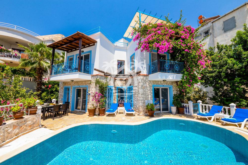 Kalkan merkez korunaklı villa havuz başı şezlong ve şemsiyeler.