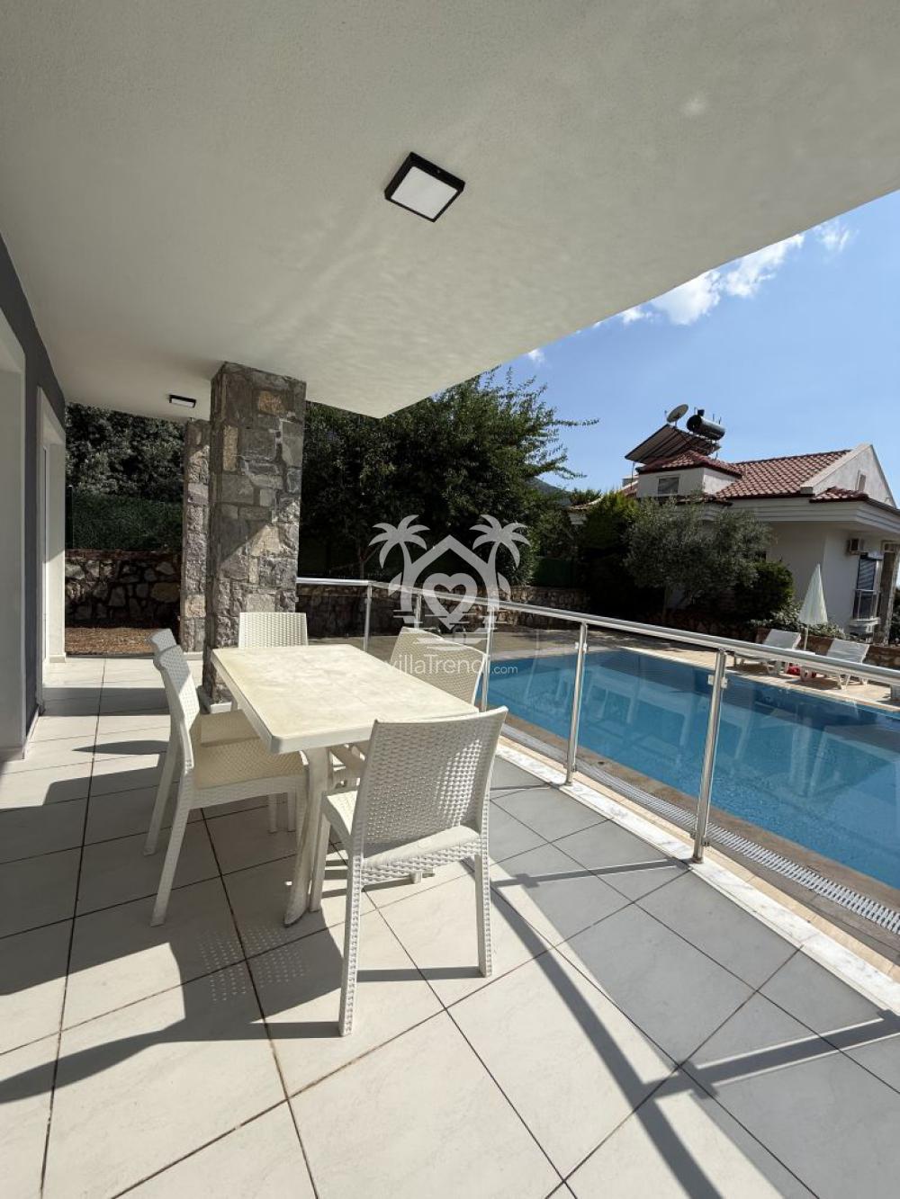Villa Bella Ölüdeniz havuz başı gölgelikli yemek masası ve teras alanı.
