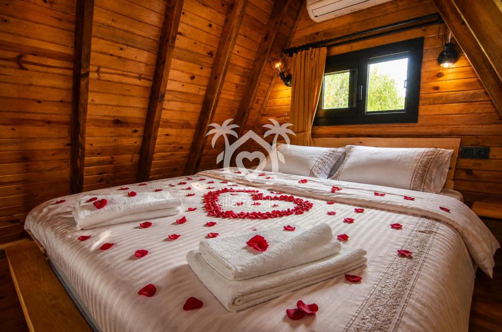 Fethiye Kayaköy balayı bungalovu Trend 1 gül yapraklarıyla süslenmiş romantik yatak odası.