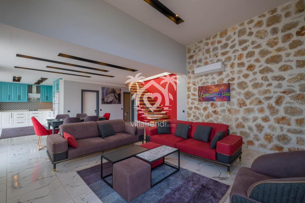 Villa Karaorman Kalkan'ın şık taş duvar detaylarına sahip geniş modern salonu.