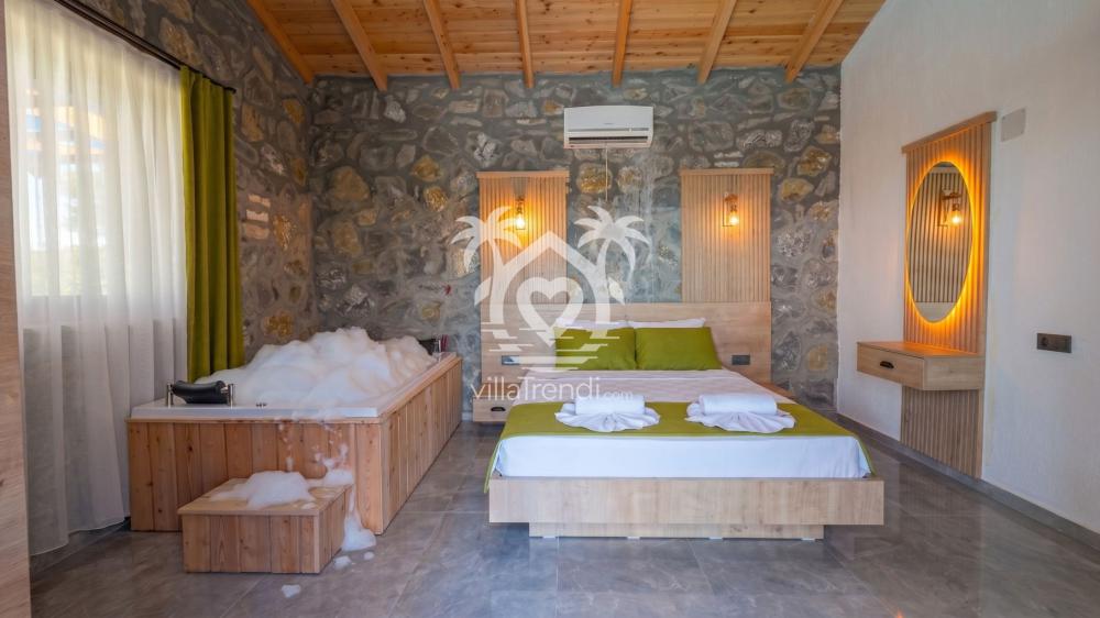 Villa Meyra odasında özel jakuzi bulunan lüks ebeveyn yatak odası.