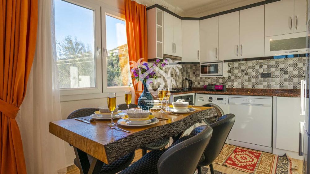 Kalkan İslamlar Villa Özlü açık plan mutfak ve yemek masası.