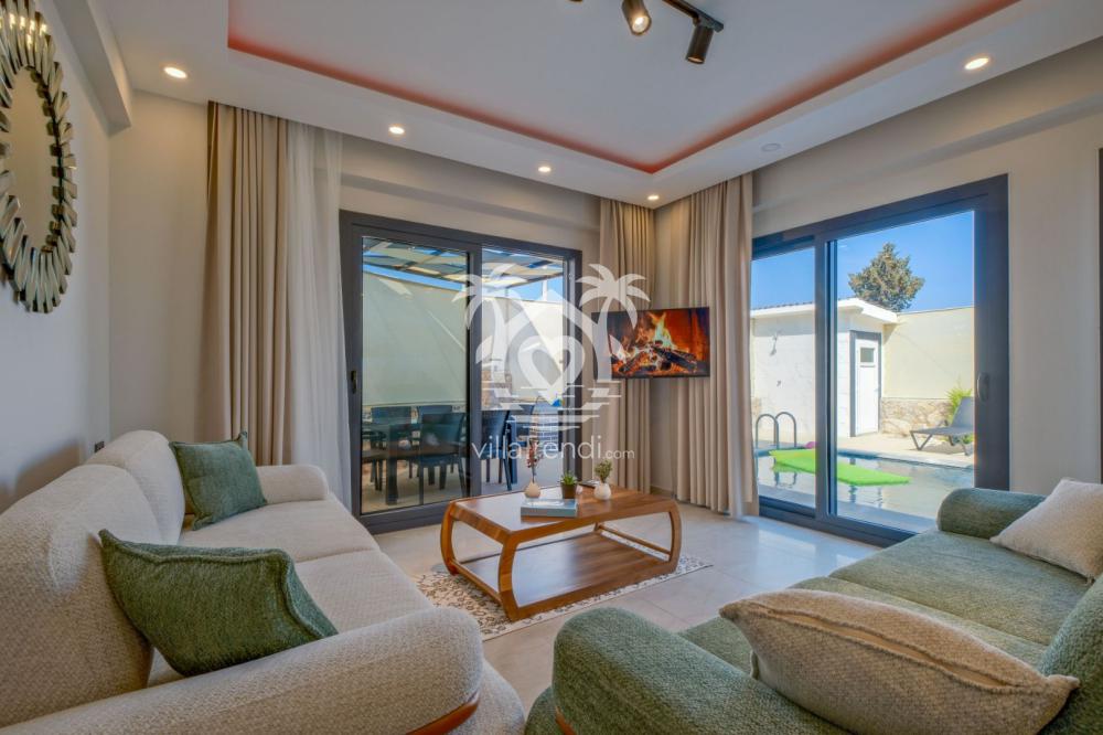 Modern ve şık dekorasyona sahip Villa Zeus 1'in ferah oturma odası ve havuz manzaralı salonu.